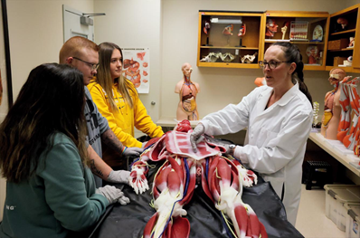 Dr. Megan Dischiavo, of Biology and Chemistry, works with students in a lab