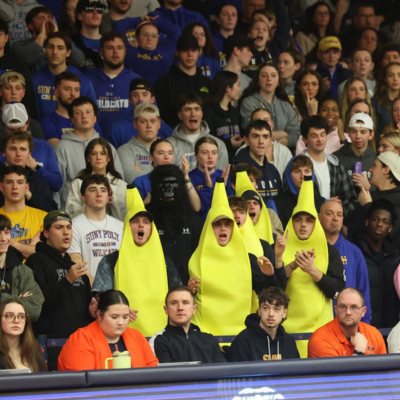 Students cheering on basketball game in banana outfit