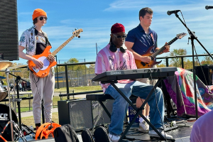 three people playing music in a band outside